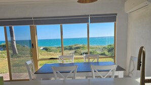 A kitchen with a view of the ocean, a dining table with chairs, and a Bosch dishwasher. - Oceanfront retreat with breathtaking views steps from the shore. (Ledge Point)