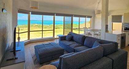 Oceanfront retreat with breathtaking views steps from the shore.