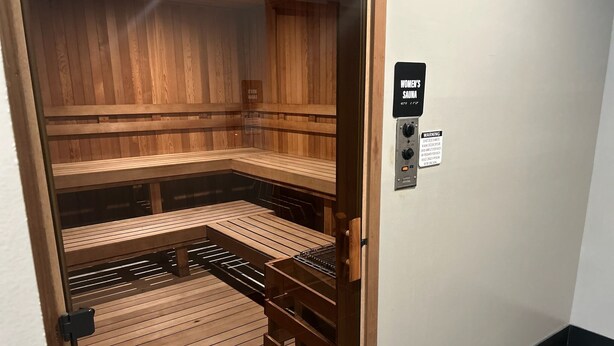 Een sauna met houten banken en een bedieningspaneel.