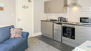 A compact kitchen with a refrigerator, oven, microwave, and a toaster. - A great apartment so close to the beach and harbour and within the town centre. (Bridlington)