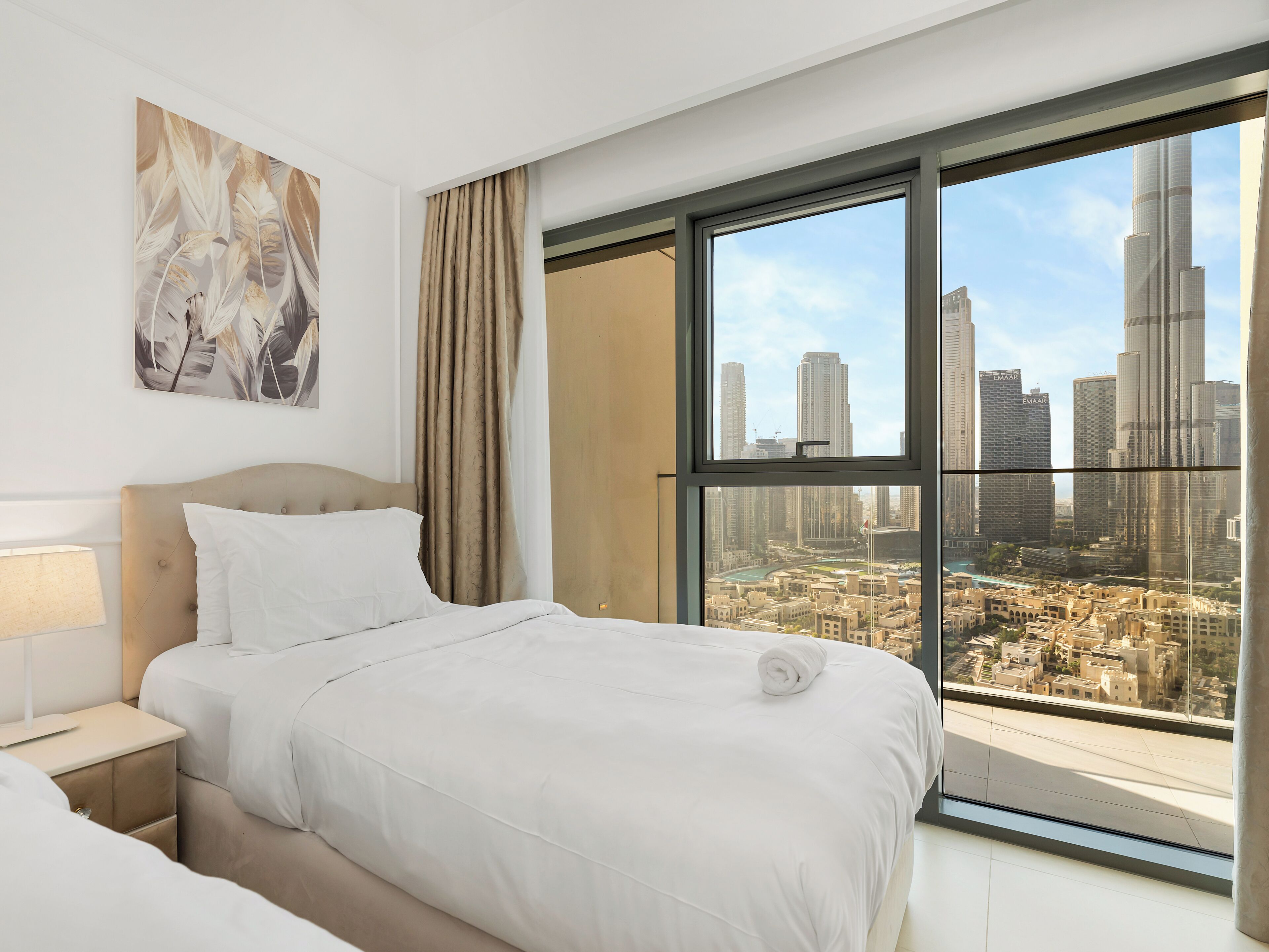 Ein Hotelzimmer mit großem Fenster und Blick auf die Stadt, einem ordentlich bezogenen Bett und modernem Design.