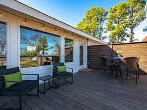 Une terrasse dotée de mobilier d’extérieur et offrant une vue sur les arbres.
