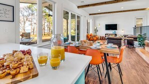A spacious dining area with a breakfast spread, large windows, and a view of the outdoors. - Lago Vista- Waterfront | Kayaks | Views! (Wills Point)