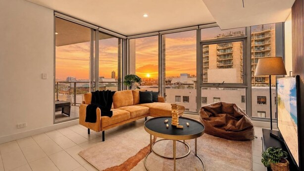 A modern living room with a sofa, a coffee table, and a bean bag chair. - Moody Luxe Designer 2BR • Dark Oak • Surry Hills (Surry Hills)