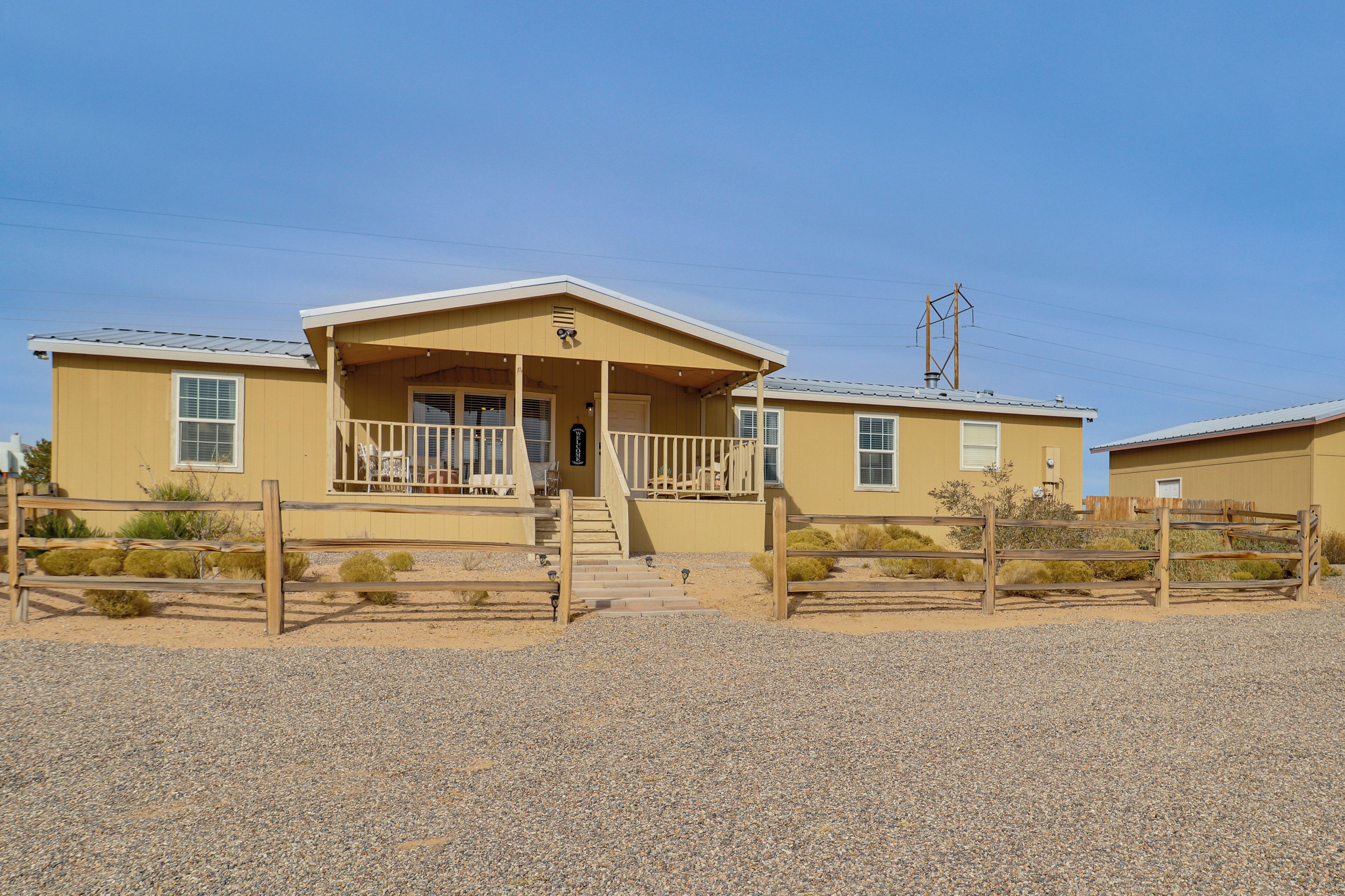 A yellow building with a porch and steps leading to the entrance.