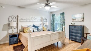 A bedroom with a bed, nightstands, a dresser, a ceiling fan, and a painting on the wall. - Golf, Shop & Unwind: Home w/ Patio in The Villages (The Villages)