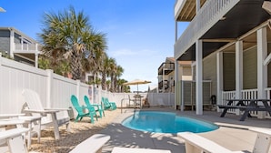 A pool area with lounge chairs, a table, and a deck. - Isle Always Luv View-New To Rental Market, 5beds/Pet Friendly/Ocean Views (ocean isle beach)