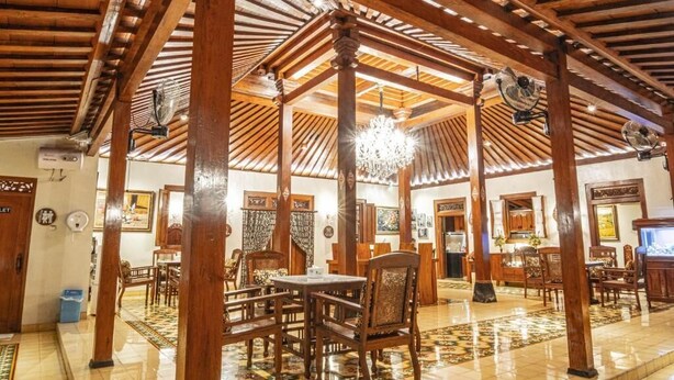 A spacious room with wooden beams, a chandelier, and a tiled floor. - Ndalem Kartowikoro 1835 (Surakarta)