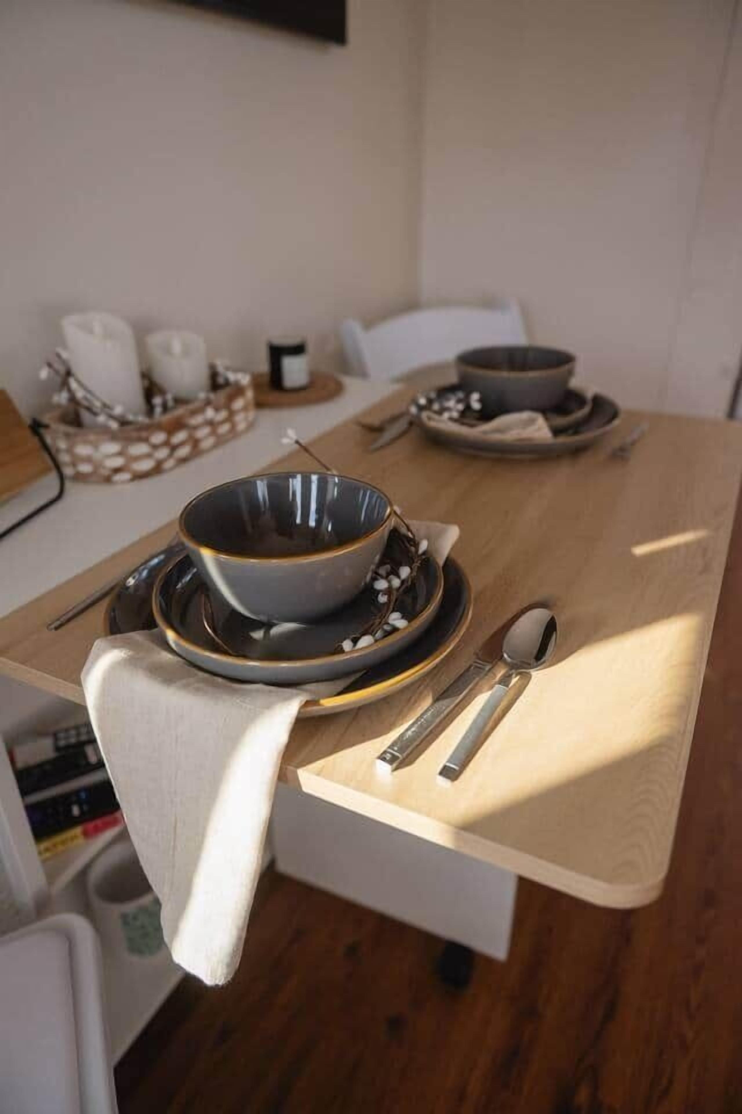A dining table set with a bowl, plates, and cutlery.