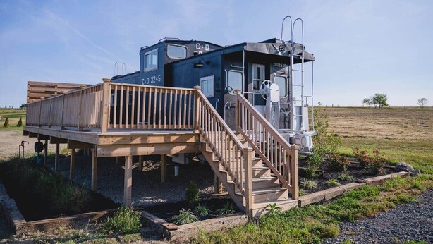 Een chalet met een houten terras en een trap naar een klein portaal.