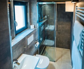 Ein modernes Badezimmer mit einer Duschkabine, einer Toilette und einem Waschbecken.