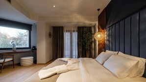 Ein modernes Schlafzimmer mit einem großen Bett, einem Schreibtisch und einem Fenster mit Vorhängen.