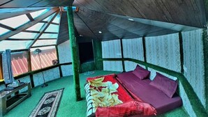 A room with a bed, a small table, and a window. - Anany Resort (Pangoot)