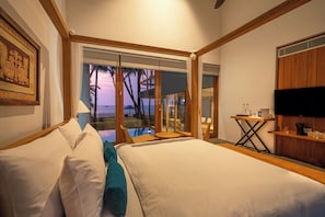 A hotel room with a large bed, a TV, a small table, and a view of the ocean. - The Coast Sri Lanka, Bentota (Induruwa)