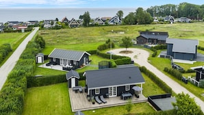A residential area with houses, a grassy field, and a body of water in the background. - "Rixa" - 350m from the sea by Interhome (Frørup)