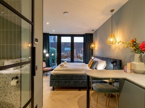 A modern bedroom with a large bed, a desk, and a view of the outdoors. - Vacation home Zee by Interhome (Koudekerke)