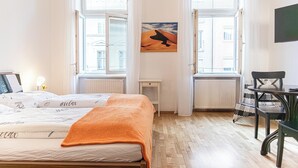 Une chambre à coucher avec un lit, un tableau, un bureau et une chaise.