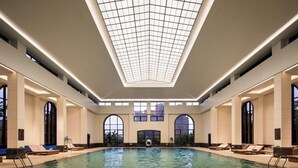 A large indoor swimming pool with a skylight ceiling, sun loungers, and large windows. - Hangzhou Leisure Lake The Dragon (Hangzhou)