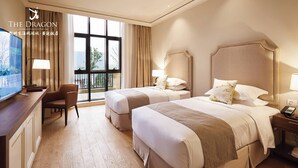 A hotel room with two beds, a desk with a TV, and a view of the city through large windows. - Hangzhou Leisure Lake The Dragon (Hangzhou)