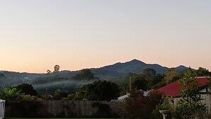 A residential area with a view of a mountain range. - The Wonky House (Bowraville)
