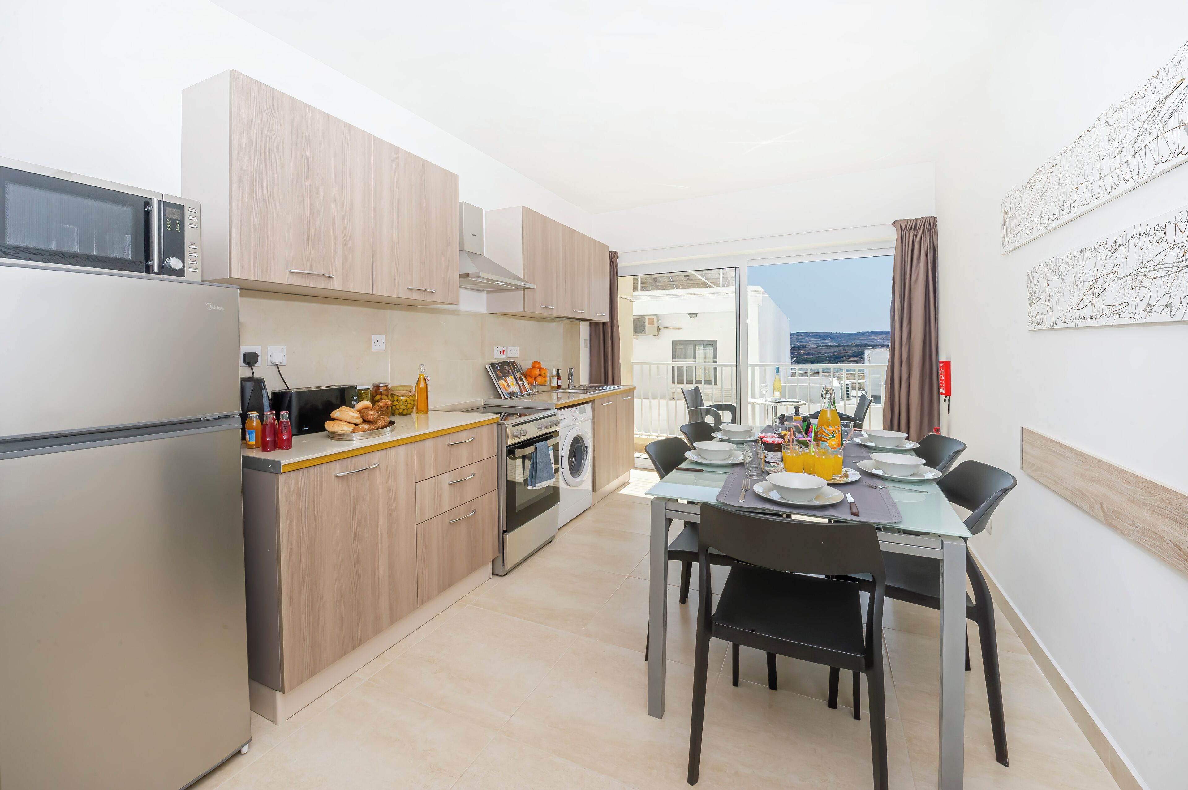 Una cocina moderna con comedor, lavadora y vistas a la ciudad.