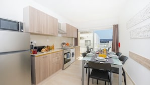 Eine moderne Küche mit Essbereich, einer Waschmaschine und Blick auf die Stadt.