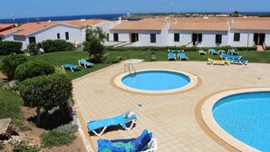 Area piscina con lettini e vista sul mare.