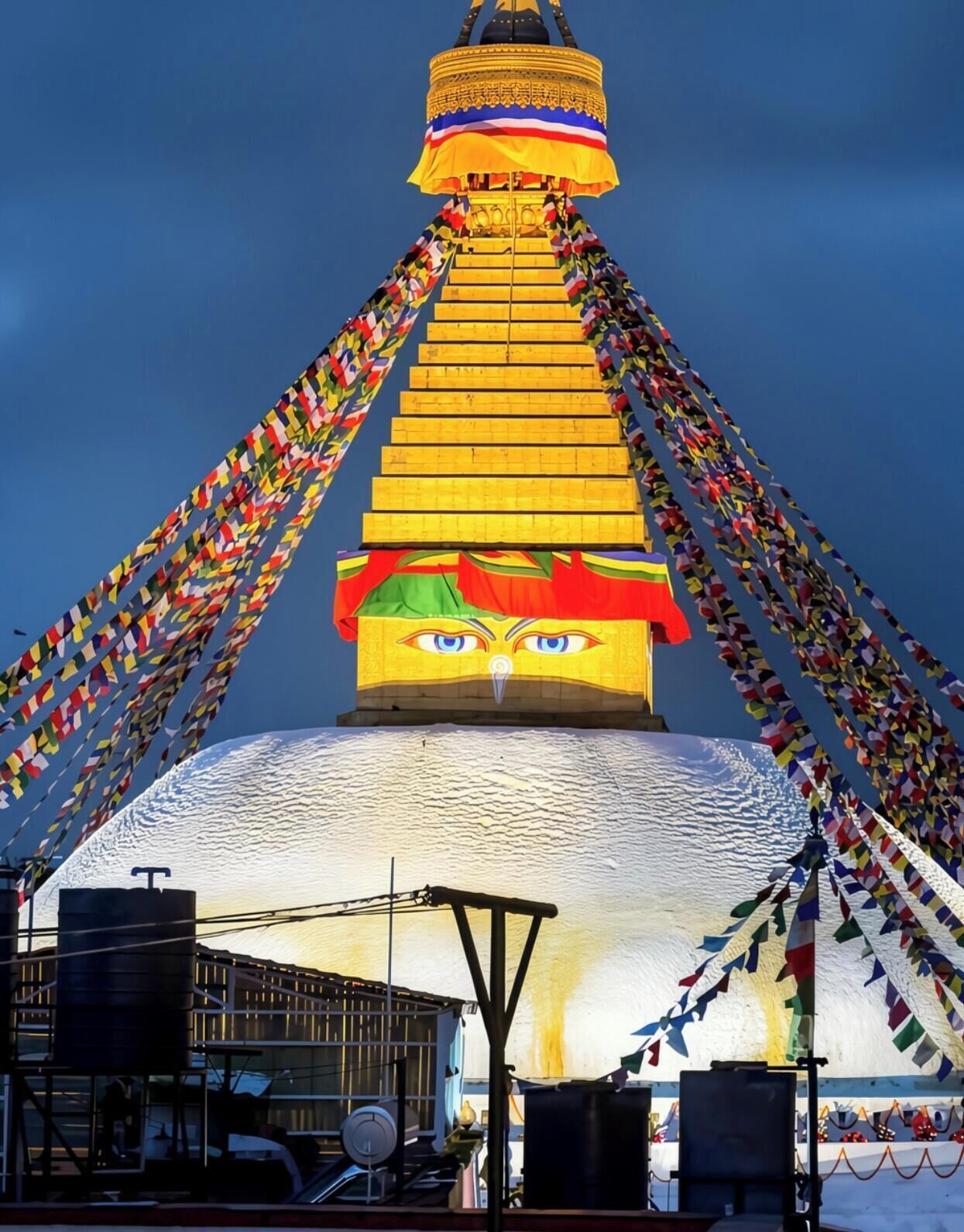 Un'imponente struttura decorata, con una guglia dorata e colorate preghiere tibetane.