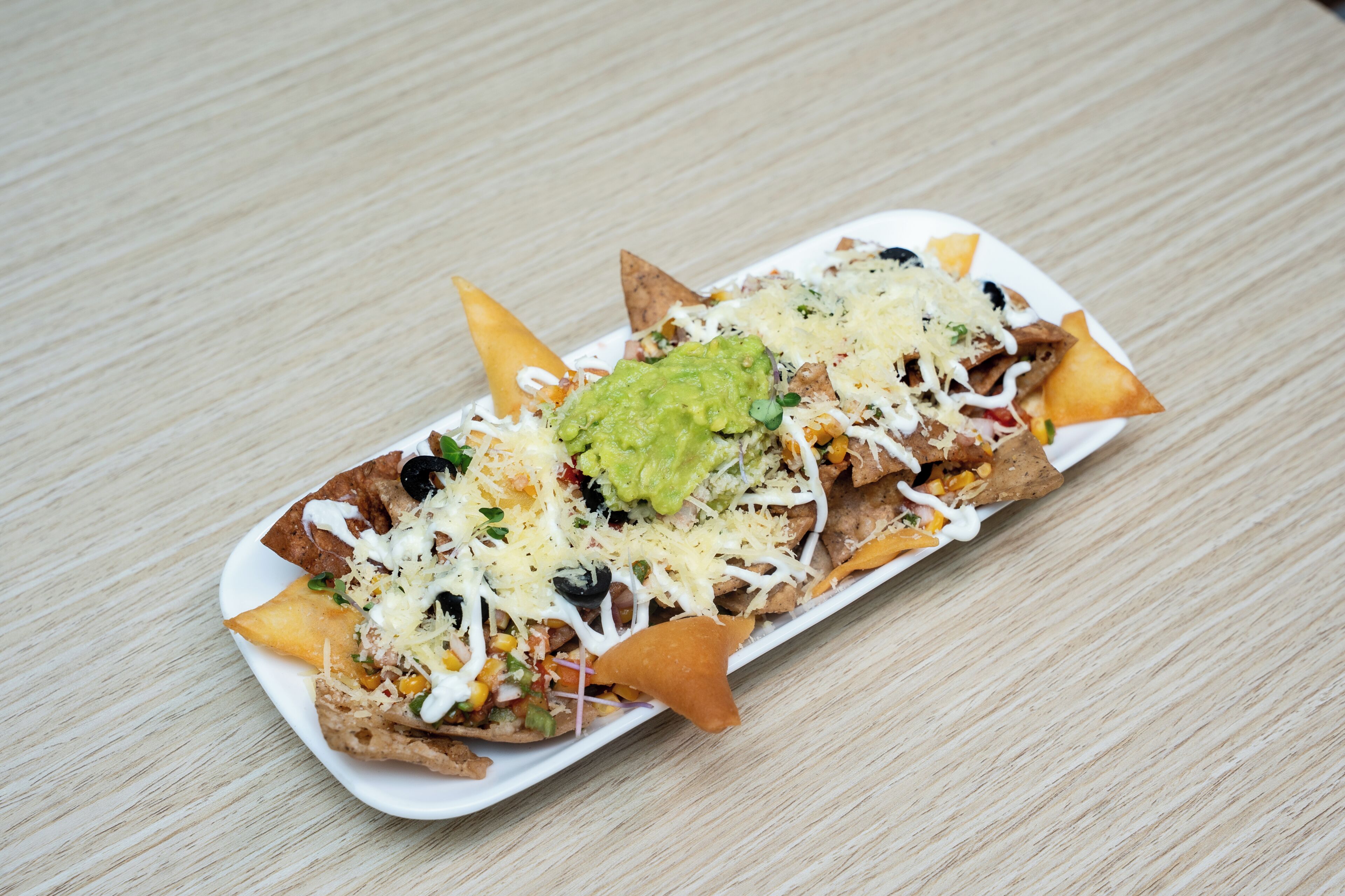 A plate of nachos with toppings.