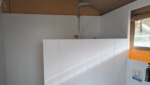 Un baño pequeño y funcional con ducha, inodoro y lavamanos.