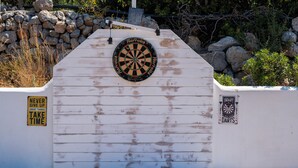 Un dardo fijado en una pared de madera blanca con un cartel que dice 