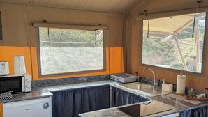 Una cocina pequeña con un lavamanos, un microondas y un refrigerador.
