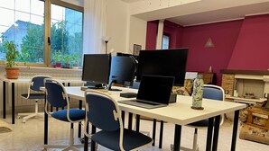 Ein moderner Arbeitsplatz mit mehreren Arbeitsstationen, darunter Schreibtische mit Computern und Stühlen.