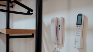 Um telefone branco e um dispositivo digital fixados na parede.