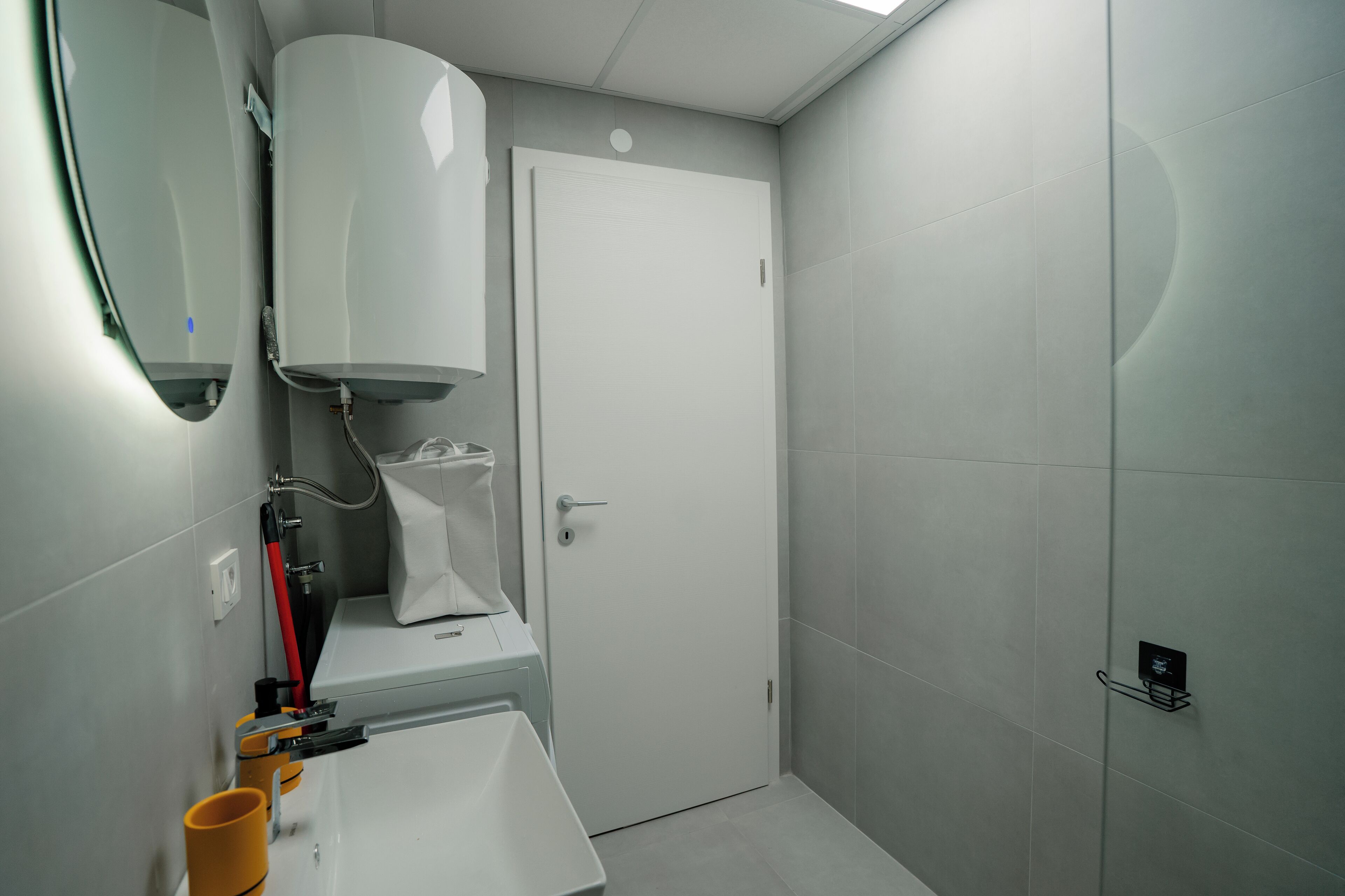 Un baño moderno con inodoro, lavamanos y zona de ducha.