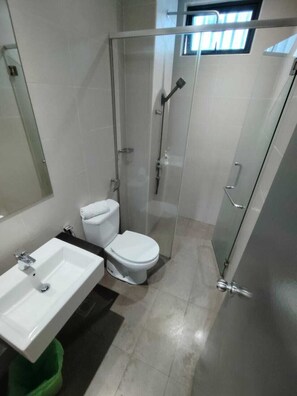Ein Badezimmer mit Duschkabine, Toilette und Waschbecken.