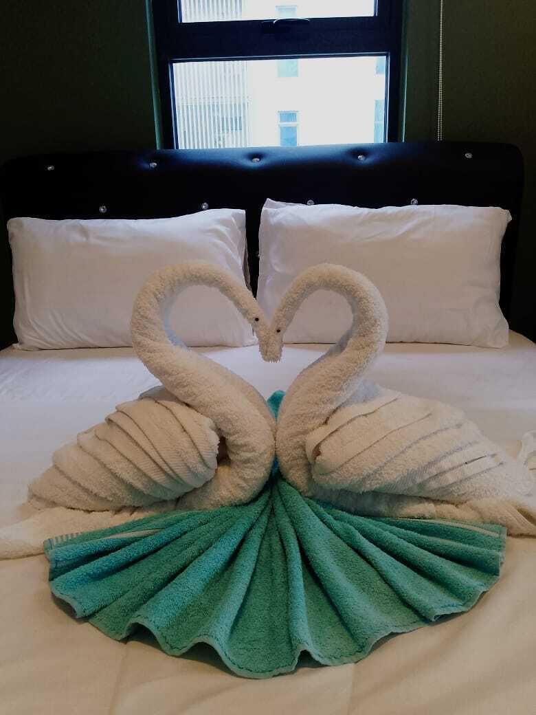Een bed met een decoratieve zwaan van handdoeken.