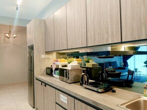 Eine moderne Küche mit Holzschränken, einem Backofen, einer Kaffeemaschine und einem Spülbecken.