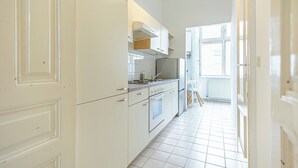 A modern kitchen with white cabinetry, a built-in oven, and a window providing natural light. - Stylish 1BR Apartment In Vienna Center (Vienna)