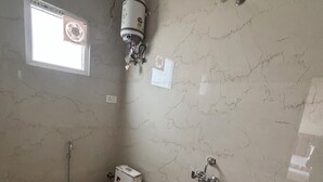 A bathroom with a toilet, a shower, a sink, and a window. - Hotel Kajal Inn (Ajmer)