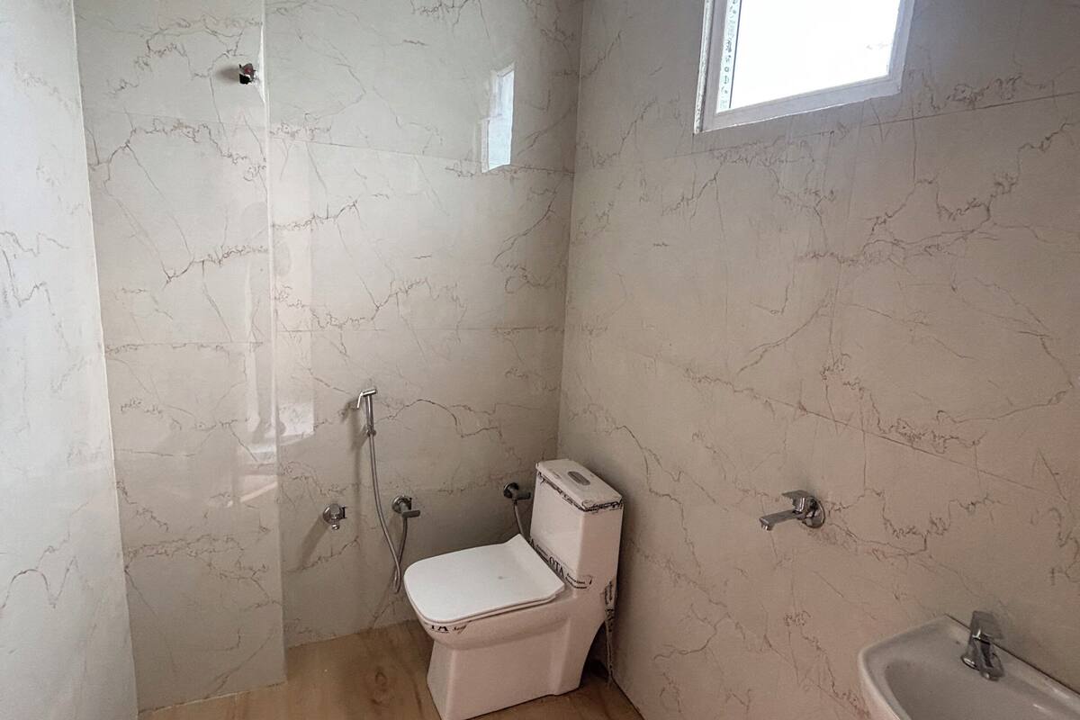 A bathroom with a toilet, sink, and shower.