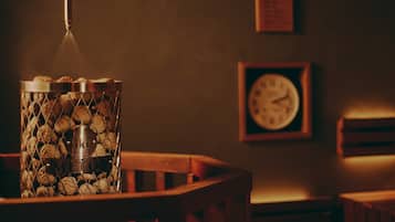 Un recipiente metálico con etiqueta, una silla de madera y un reloj de pared.