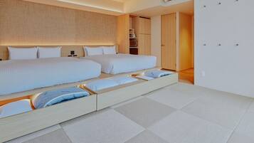 A modern hotel room with a large bed, built-in storage, and a visible air conditioning unit.