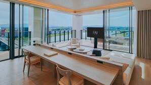 A modern hotel room with a large window, a flat-screen TV, a wooden desk, and a sofa. - FAV LUX MIYAZAKI (Miyazaki)