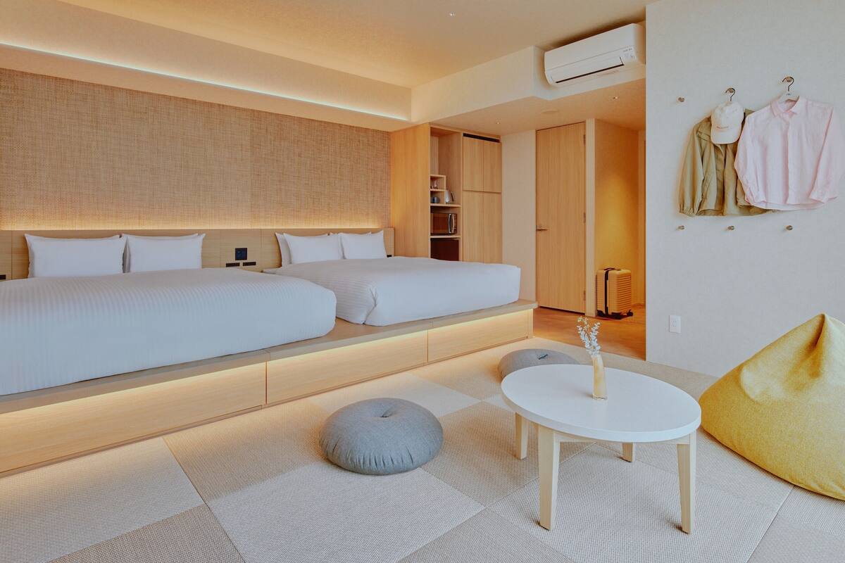 A modern hotel room with a large bed, a small table, and a seating area.