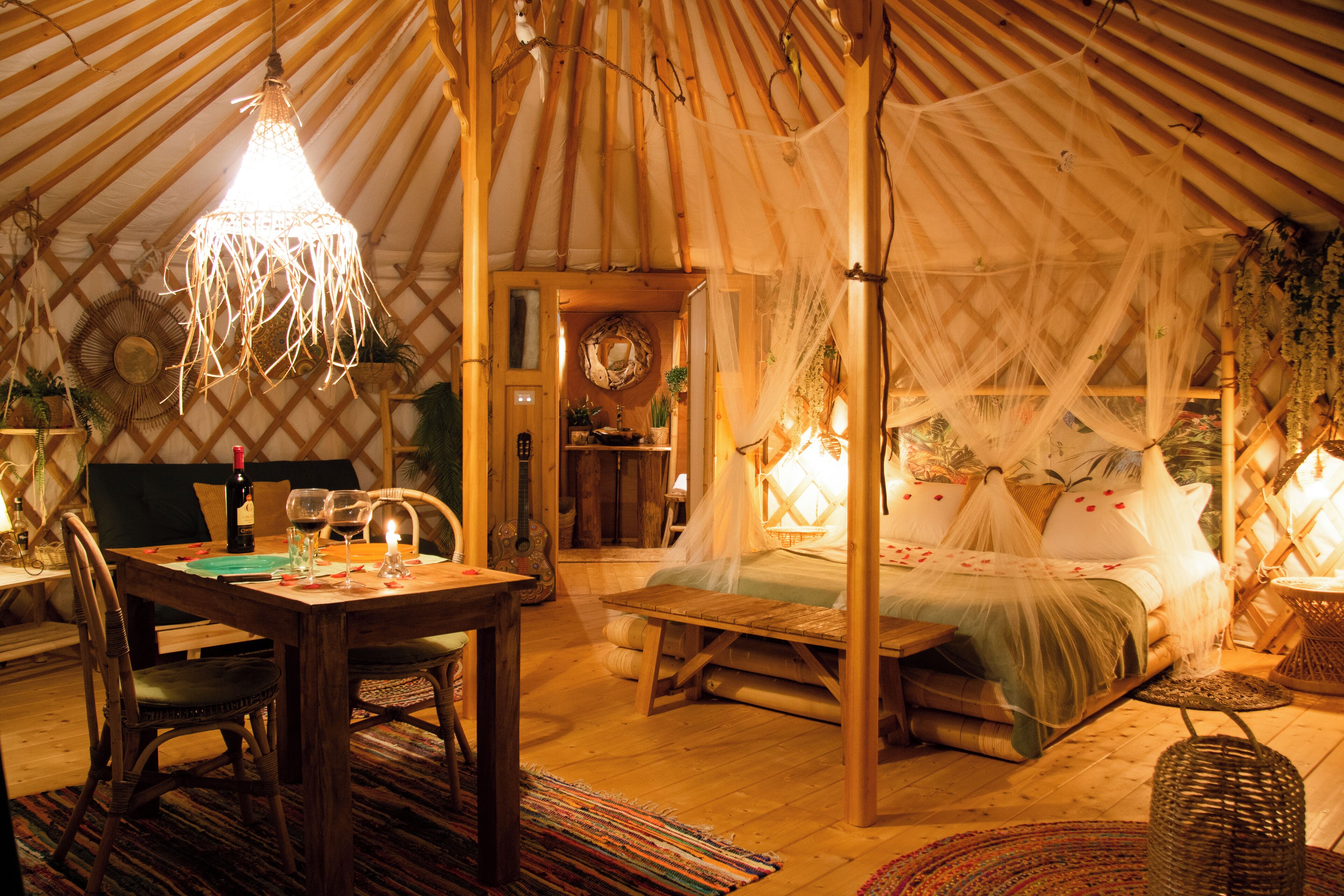 Una tenda accogliente e luminosa con un letto, un'area pranzo e una piccola cucina.