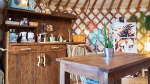 Eine rustikale Küche mit Holzschränken, einem Vintage-Toaster und einem Ventilator.