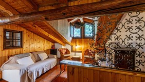 A cozy wooden cabin interior with a sofa, chairs, a fireplace, and a hanging plant. - 🏠 PROPERTY DESCRIPTIONWelcome to Casa Alpina, in the heart of La Thuile, Valle d’Aosta. A typical mountain apartment, cozy and comfortable, immersed in the tranquility of an alpine village. Ideal for those seeking relaxation, nature, and ski slopes  (La Thuile)