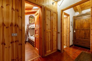 A wooden interior with a bunk bed, wooden doors, and a bed with a headboard. - 🏠 PROPERTY DESCRIPTIONWelcome to Casa Alpina, in the heart of La Thuile, Valle d’Aosta. A typical mountain apartment, cozy and comfortable, immersed in the tranquility of an alpine village. Ideal for those seeking relaxation, nature, and ski slopes  (La Thuile)