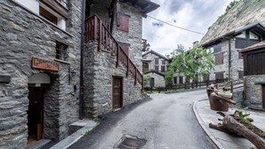 A narrow street with stone buildings, a wooden sign reading 'GRANCEON,' and a rustic wooden fence. - 🏠 PROPERTY DESCRIPTIONWelcome to Casa Alpina, in the heart of La Thuile, Valle d’Aosta. A typical mountain apartment, cozy and comfortable, immersed in the tranquility of an alpine village. Ideal for those seeking relaxation, nature, and ski slopes  (La Thuile)
